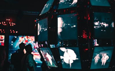 a group of people standing around a display of video screens