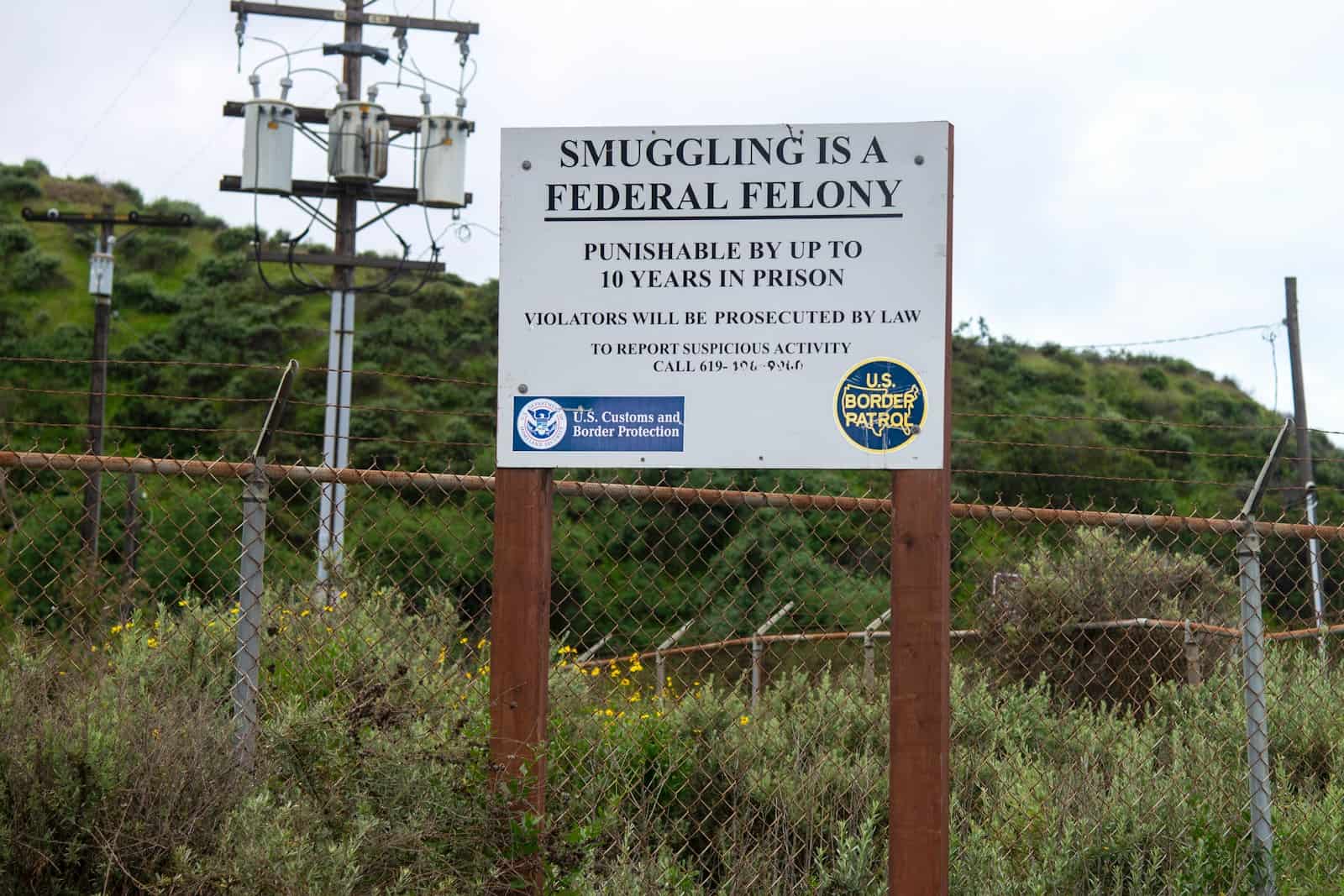 a sign is posted on a fence near a field